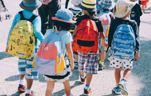grupo de crianças andando na rua, usando mochilas escolares e roupas coloridas — capa do conteúdo sobre as melhores escolas particulares do Rio de Janeiro