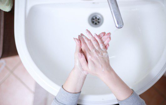 Foto que ilustra matéria sobre crise hídrica e energética em condomínios mostra duas mãos se lavando em uma pia