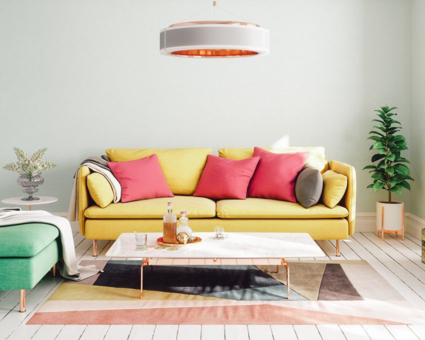A foto mostra um exemplo de decoração retrô em uma sala de estar. Na imagem há: sofá, poltrona, mesa de centro, luminária de teto, tapete e plantas.