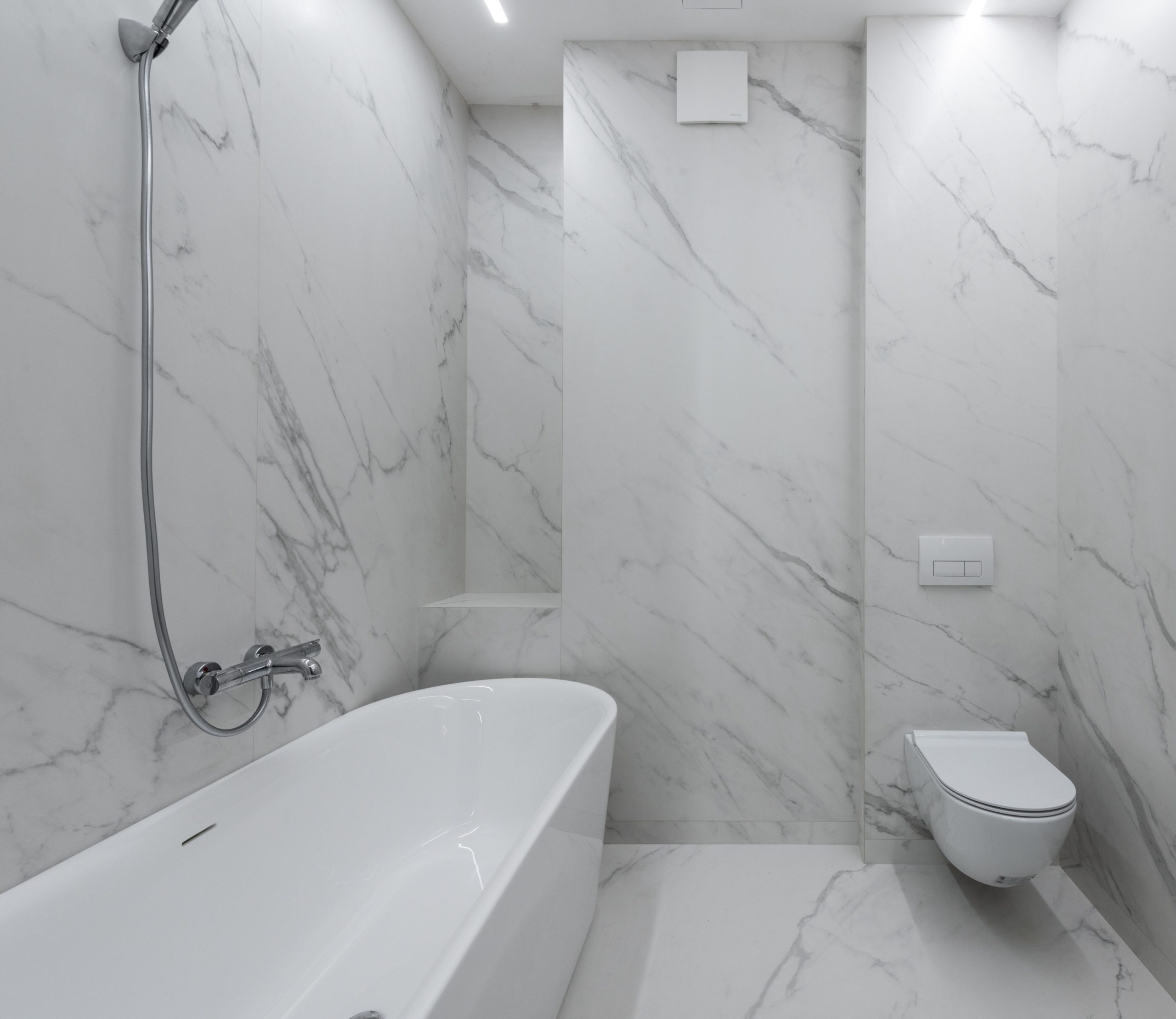 Uma boa ideia é decorar o banheiro usando um mesmo padrão de revestimento, como este da imagem onde o porcelanato imita o mármore.