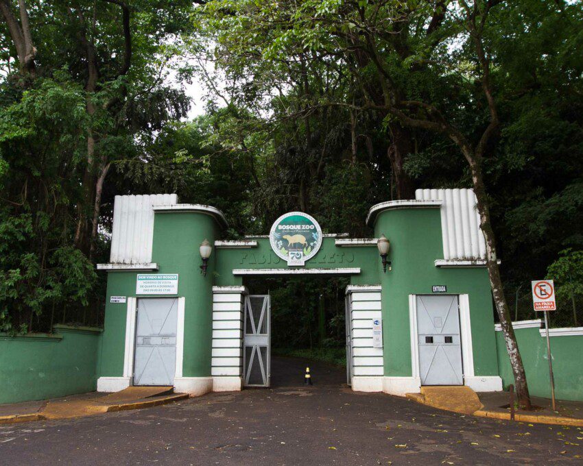 Foto que ilustra matéria sobre o Zoológico Ribeirão Preto mostra a entrada do Zoológico com árvores no seu entorno.