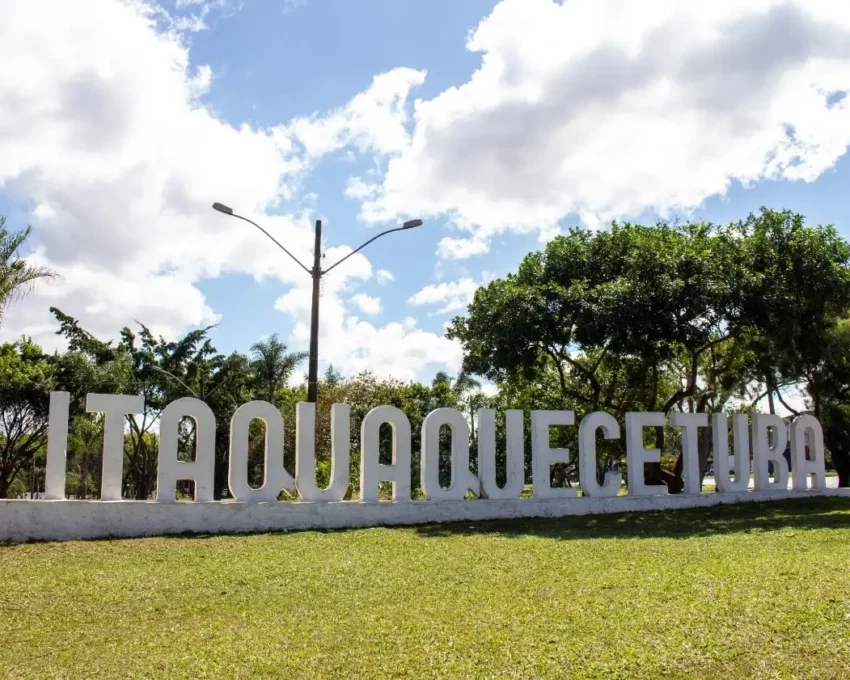 Foto que ilustra matéria sobre Bairros de Itaquaquecetuba mostra um letreiro com o nome da cidade sobre um gramado
