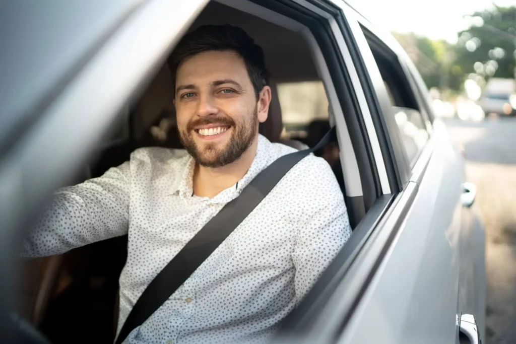 Imagem de um homem dentro de um carro com sorriso estampado no rosto para ilustrar matéria sobre trânsito de São Paulo