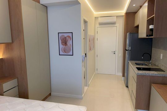Quarto com cama, armários e móveis de madeira, iluminação adequada e piso de cerâmica. de kitnet/studio à venda com 1 quarto, 25m² em Vila Clementino, São Paulo