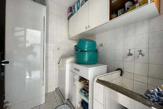 Cozinha com geladeira, fogão e pia, com móveis brancos e azuis, e azulejos brancos no chão e nas paredes. de casa à venda com 4 quartos, 200m² em Jardim Porteira Grande, São Paulo