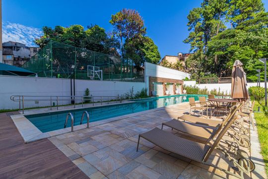 Piscina com deck e churrasqueira ao lado, cercada por árvores e edifícios na área ao redor. de apartamento à venda com 2 quartos, 65m² em Jardim Umuarama, São Paulo