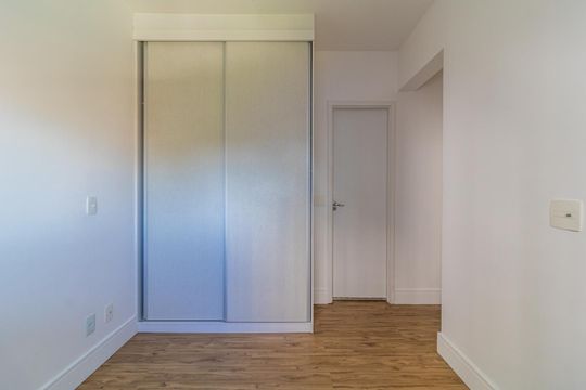 Cuarto com armário de madeira e piso de madeira, iluminado por luz natural. de apartamento à venda com 2 quartos, 65m² em Jardim Umuarama, São Paulo