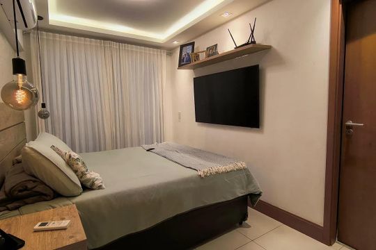Quarto simples com cama, TV e iluminação adequada. de apartamento à venda com 5 quartos, 150m² em Recreio dos Bandeirantes, Rio de Janeiro