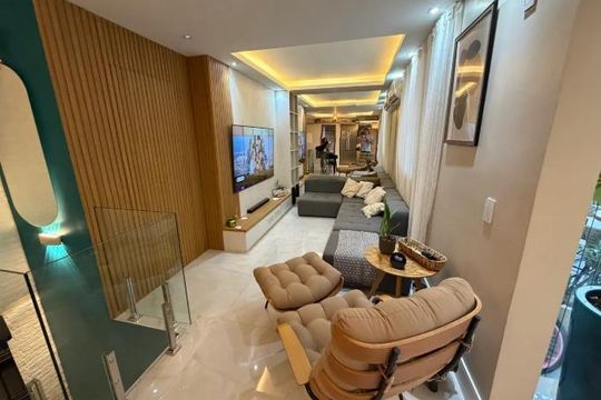Sala de estar com sofá, TV e mesa de centro, iluminada com luzes de parede e teto. de apartamento à venda com 5 quartos, 150m² em Recreio dos Bandeirantes, Rio de Janeiro