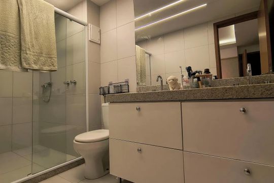 Banheiro com piso de porcelanato, pia de granito e espelho grande. de apartamento à venda com 5 quartos, 150m² em Recreio dos Bandeirantes, Rio de Janeiro