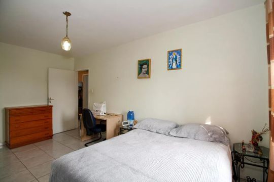 Quarto com cama, armário e mesa de trabalho, com decoração simples e iluminação adequada. de apartamento à venda com 3 quartos, 98m² em Vila Madalena, São Paulo