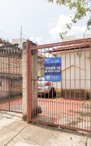 Casa à venda com 226m², 12 quartos e 4 vagasPortão de entrada do imóvel e placa Quinto Andar