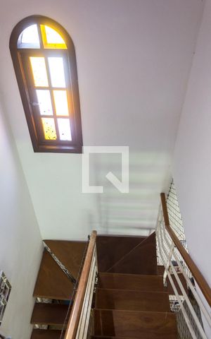 Casa para alugar com 400m², 2 quartos e 2 vagasEscada descendo para a sala e subindo para as suítes