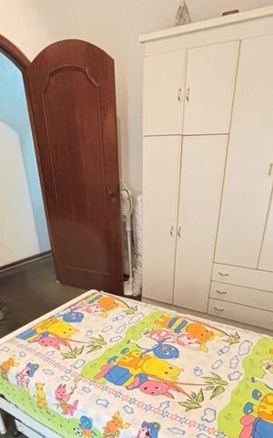 Casa à venda com 170m², 4 quartos e 5 vagasQuarto com cama de solteiro, armário de madeira e prateleiras com objetos decorativos.