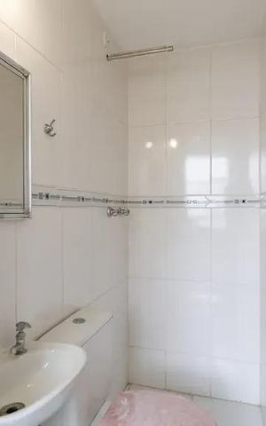 Apartamento à venda com 60m², 2 quartos e 2 vagasBanheiro com piso de porcelanato, banheira e espelho, com iluminação adequada.