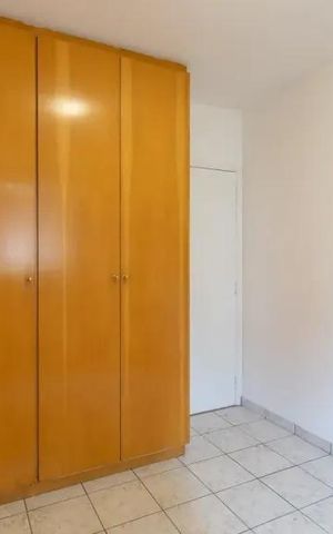 Apartamento à venda com 60m², 2 quartos e 2 vagasCabinete de madeira claro em uma sala com piso de porcelanato e iluminação natural.