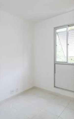 Apartamento à venda com 60m², 2 quartos e 2 vagasQuarto com paredes brancas, piso de porcelanato e janela com persianas fechadas.