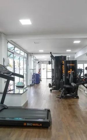 Apartamento à venda com 60m², 2 quartos e 2 vagasGinásio com equipamentos de treino e vista para o jardim.