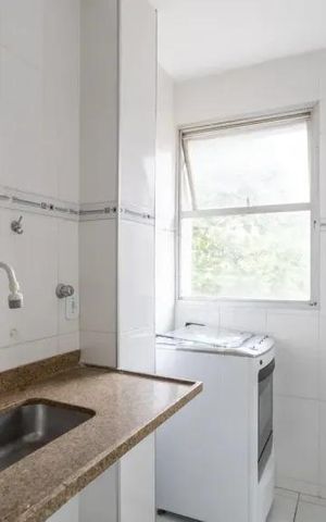 Apartamento à venda com 60m², 2 quartos e 2 vagasCozinha com pia, fogão e geladeira, com janela e iluminação natural.