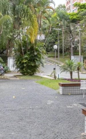 Apartamento à venda com 60m², 2 quartos e 2 vagasPátio com bancos e árvores, com vista para o prédio ao fundo.
