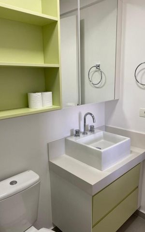 Apartamento à venda com 82m², 2 quartos e sem vagaBanheiro com pia e vaso sanitário brancos, armário com espelho e prateleiras verde-claro.