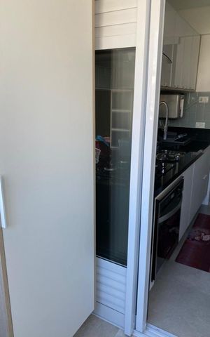 Apartamento à venda com 82m², 2 quartos e sem vagaCocina con muebles blancos y azules, con una ventana pequeña y una estufa de gas.