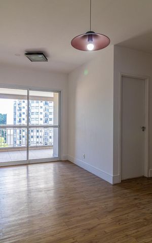 Apartamento à venda com 65m², 2 quartos e 1 vaga Apartamento à venda com 65m², 2 quartos e 1 vagaParede branca e piso de madeira, com vista para a varanda e o prédio ao fundo.