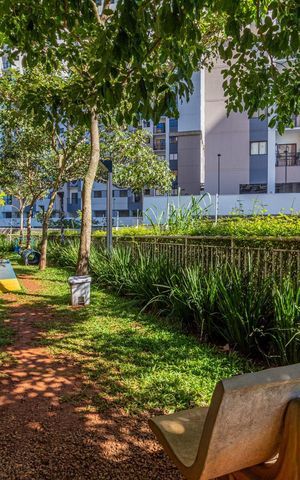 Apartamento à venda com 65m², 2 quartos e 1 vaga Apartamento à venda com 65m², 2 quartos e 1 vagaPátio com árvores e bancos, em frente a um prédio de apartamentos.