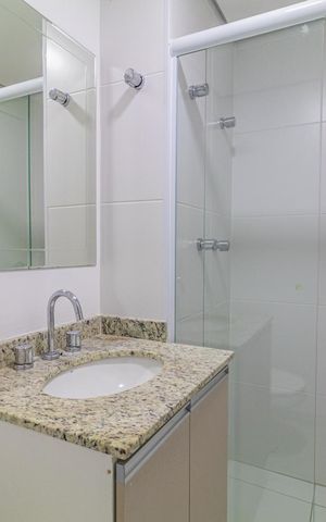 Apartamento à venda com 65m², 2 quartos e 1 vaga Apartamento à venda com 65m², 2 quartos e 1 vagaBanheiro com pia e vaso sanitário, com espelho e chuveiro, em ambiente branco e com azulejos brancos.