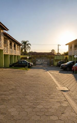Casa à venda com 80m², 2 quartos e 1 vaga Casa à venda com 80m², 2 quartos e 1 vagaPátio de um condomínio com carros estacionados e sol poente.