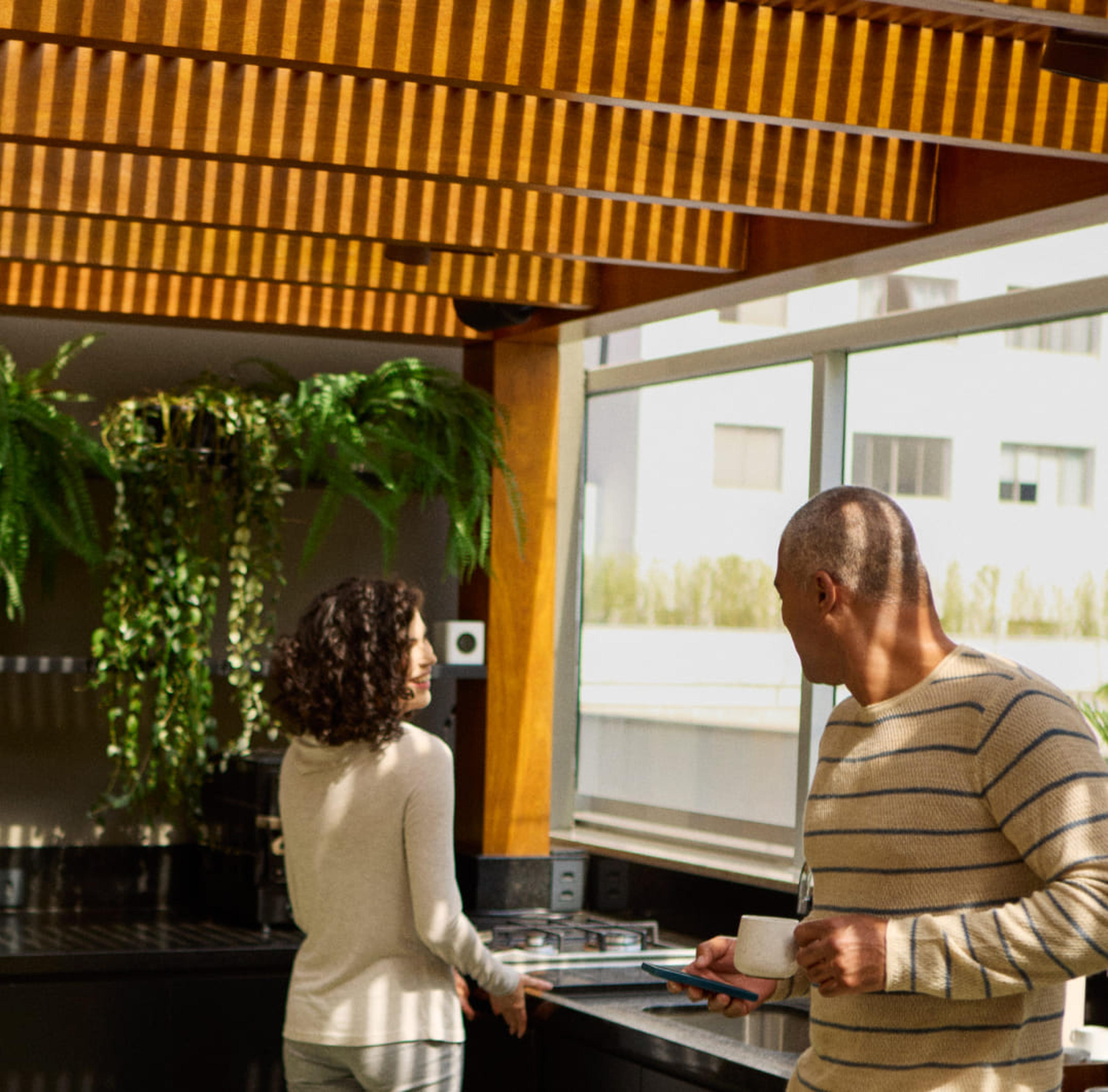 Mulher cuidando das plantas no parapeito da janela