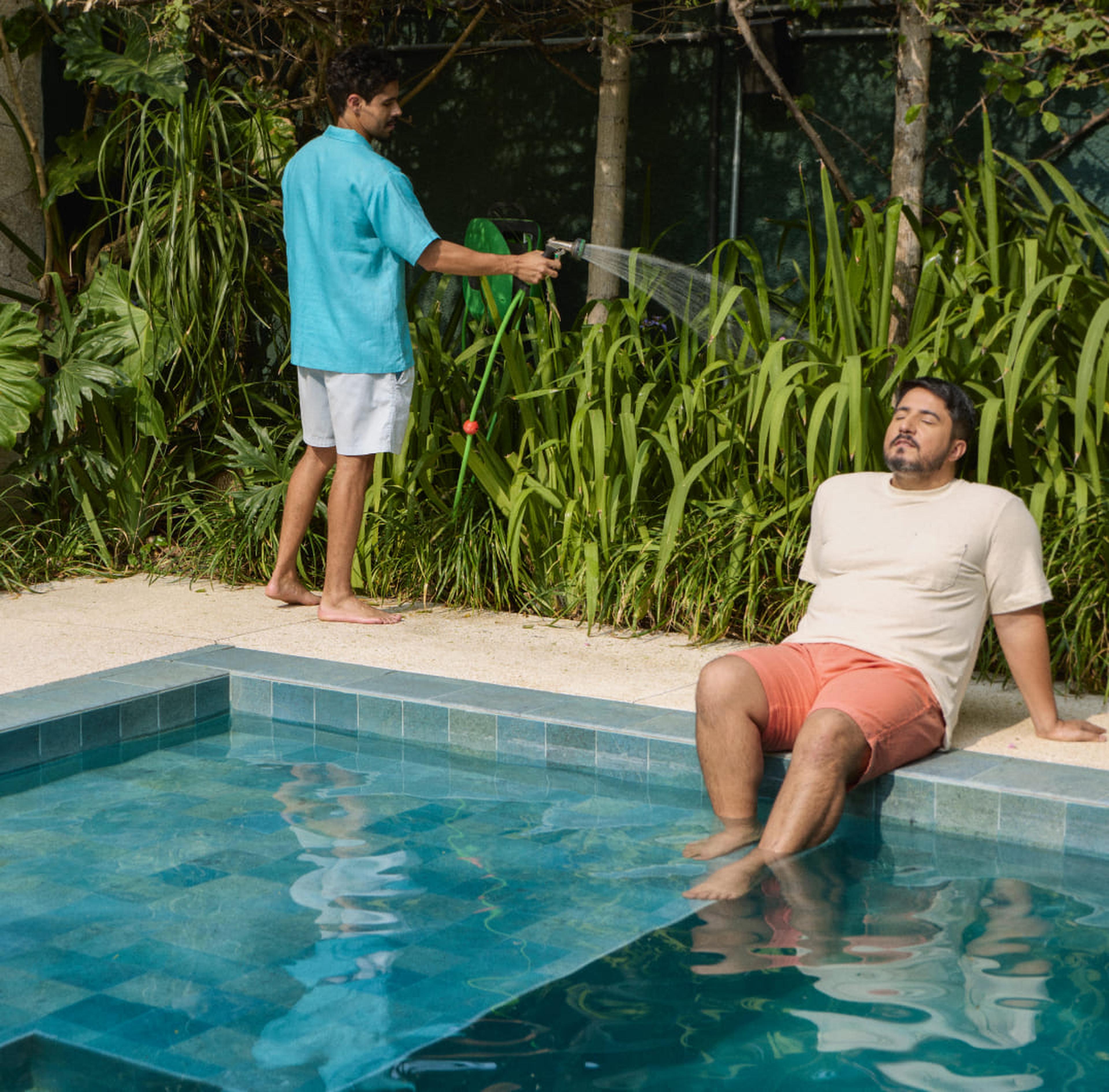 Mulher regando as plantas, com uma cadeira de praia ao lado