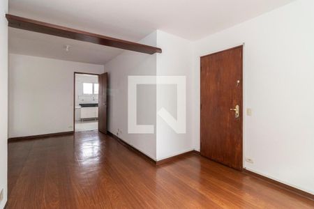 Sala com piso de madeira e porta de madeira, com uma cozinha ao fundo. de apartamento à venda com 2 quartos, 65m² em Vila Congonhas, São Paulo