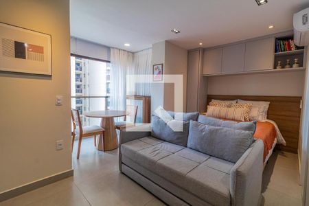 Quarto com cama de casal, sofá, mesa e cadeiras, com vista para a cidade. de apartamento à venda com 1 quarto, 28m² em Vila Nova Conceição, São Paulo