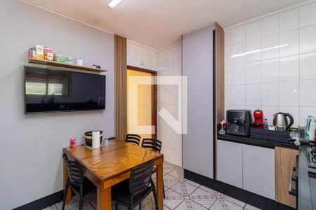 Cozinha com mesa de madeira e televisão na parede, com geladeira e fogão na bancada de granito. de casa à venda com 2 quartos, 130m² em Vila Medeiros, São Paulo