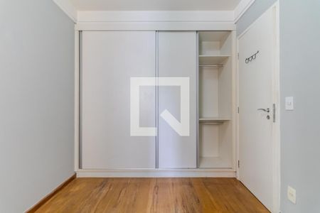Quarto com móveis brancos e madeira, com uma porta de vidro e uma janela grande, iluminado por luz natural e com um piso de madeira claro. de apartamento à venda com 2 quartos, 59m² em Lapa, São Paulo