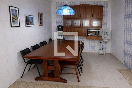 Comedor com mesa de madeira e cadeiras pretas, com iluminação azul e decoração de pinturas na parede. de casa à venda com 4 quartos, 260m² em Vila Jequitibas, Campinas
