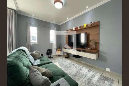 Sala com sofá verde, TV e churrasqueira, com vista para a cidade. de casa à venda com 4 quartos, 200m² em Jardim Porteira Grande, São Paulo