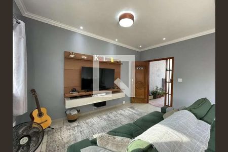 Sala com TV e sofá, com uma guitarra ao lado e uma porta de entrada ao fundo. de casa à venda com 4 quartos, 200m² em Jardim Porteira Grande, São Paulo