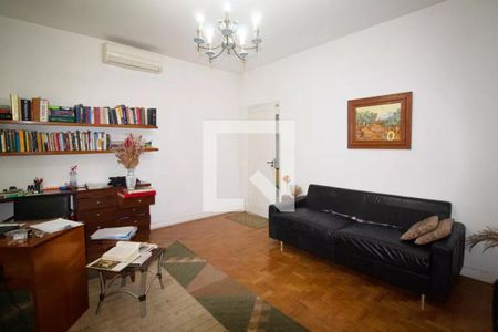 Sala com móveis de madeira e um sofá preto, com uma mesa de trabalho e uma estante de livros. de casa à venda com 4 quartos, 400m² em Pinheiros, São Paulo