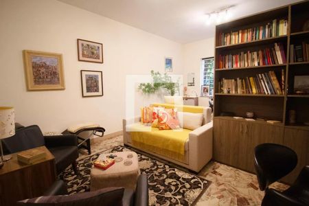 Sala com sofá, mesas e cadeiras, com decoração simples e pinturas nas paredes. de casa à venda com 4 quartos, 400m² em Pinheiros, São Paulo