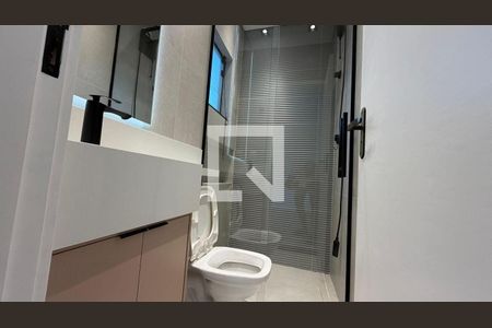 Banheiro com piso de porcelanato, vaso sanitário e espelho em cima da pia. de casa à venda com 2 quartos, 130m² em Vila Alzira, Santo André