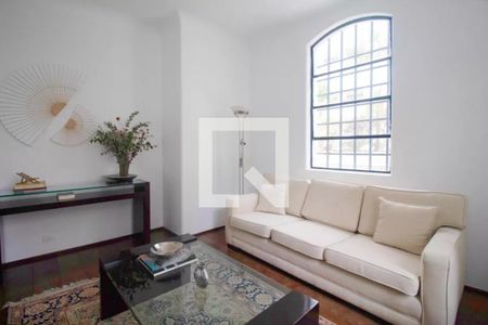 Sala de estar com sofá branco, mesa de vidro e janela grande, iluminada por lâmpadas de piso e com decoração minimalista. de apartamento à venda com 6 quartos, 244m² em Jardim Paulista, São Paulo