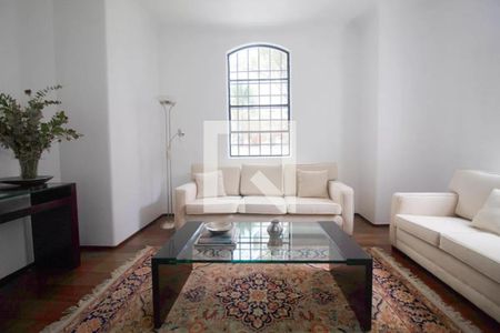 Sala de estar com sofás brancos e mesa de vidro, iluminada por lâmpadas de piso e com vista para o jardim. de apartamento à venda com 6 quartos, 244m² em Jardim Paulista, São Paulo