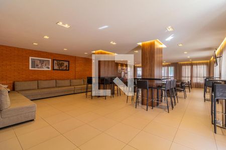 Sala de estar com sofá e mesas de bar, iluminada por lâmpadas de teto. de apartamento à venda com 2 quartos, 65m² em Jardim Umuarama, São Paulo