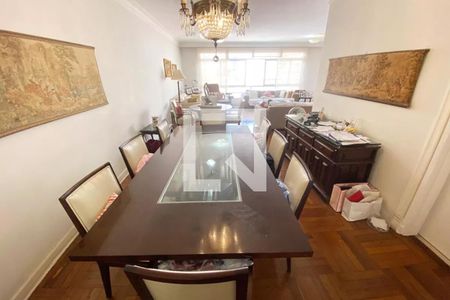 Sala de jantar com mesa de madeira e cadeiras de couro, iluminada por uma lâmpada de cristal. de apartamento à venda com 4 quartos, 185m² em Jardim Paulista, São Paulo