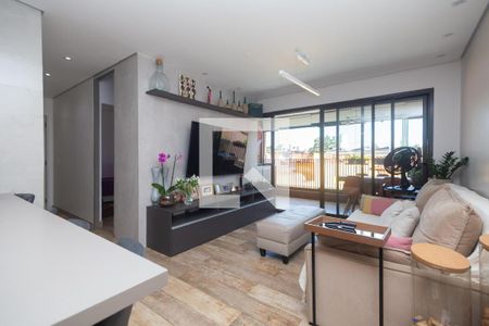Sala de estar com sofá, TV e mesa de centro, com vista para a varanda e a cidade. de apartamento à venda com 2 quartos, 81m² em Vila Monumento, São Paulo