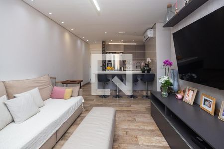Sala de estar com sofá e mesa de centro, com uma cozinha moderna ao fundo. de apartamento à venda com 2 quartos, 81m² em Vila Monumento, São Paulo