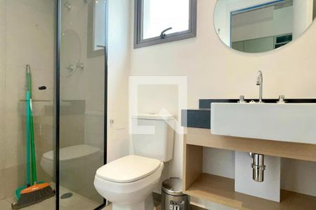 Banheiro com chuveiro e vaso sanitário branco, pia e espelho em madeira, com varanda ao fundo. de apartamento à venda com 1 quarto, 24m² em Pompeia, São Paulo