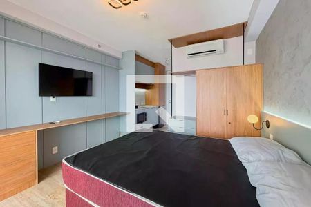 Quarto com cama, TV e ar condicionado, com uma pequena cozinha e uma porta para a varanda. de apartamento para alugar com 1 quarto, 28m² em Ipiranga, São Paulo